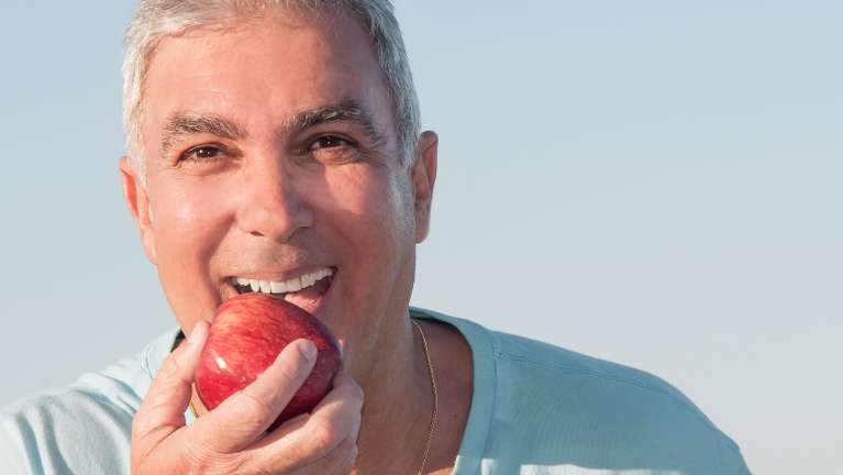 A man bitting an apple